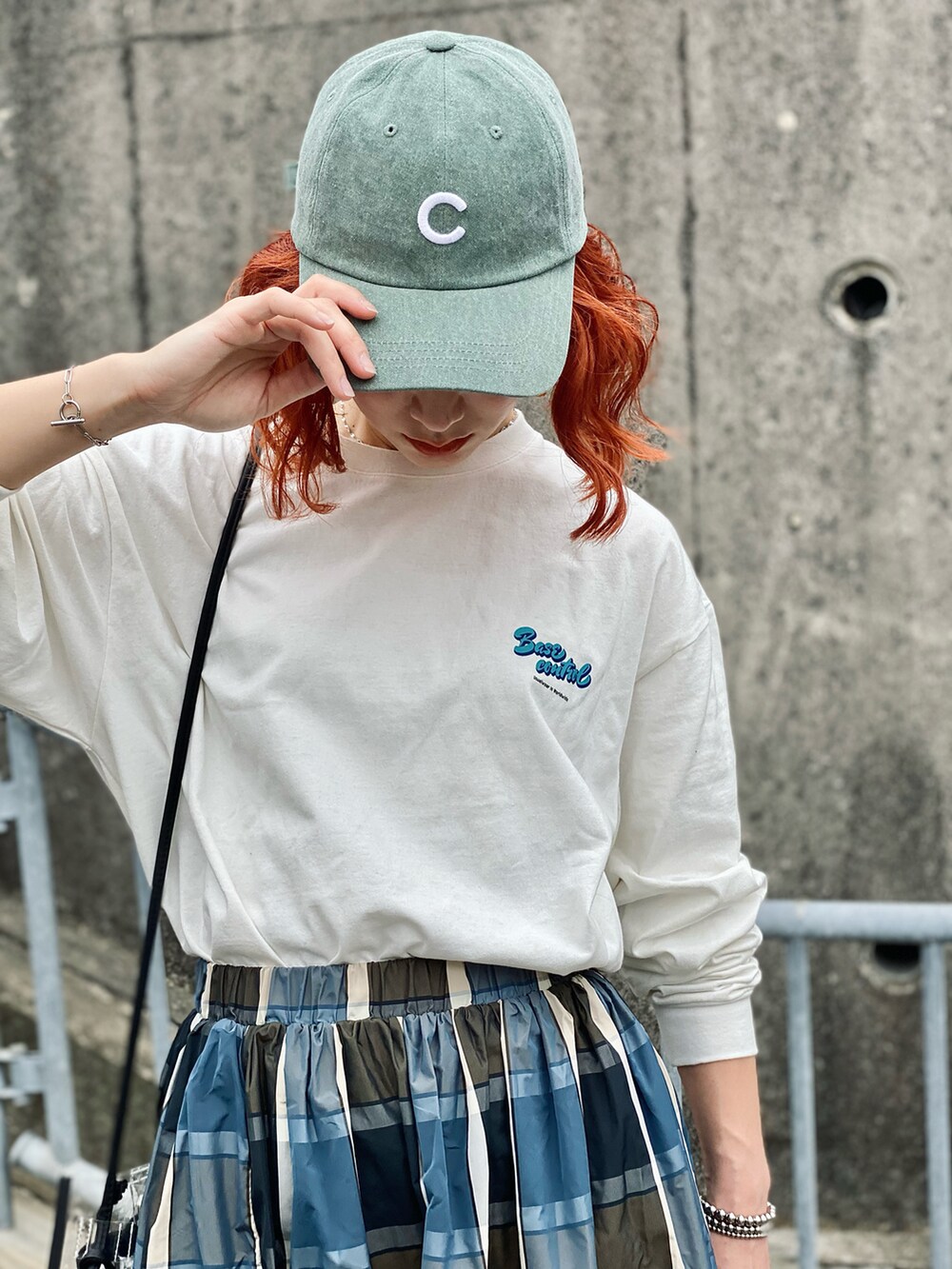 ベージュ系のTシャツ/カットソー、ホワイト系のショルダーバッグ、ブルー系のスカートを着用したレディースの春コーディネートの3枚目の写真