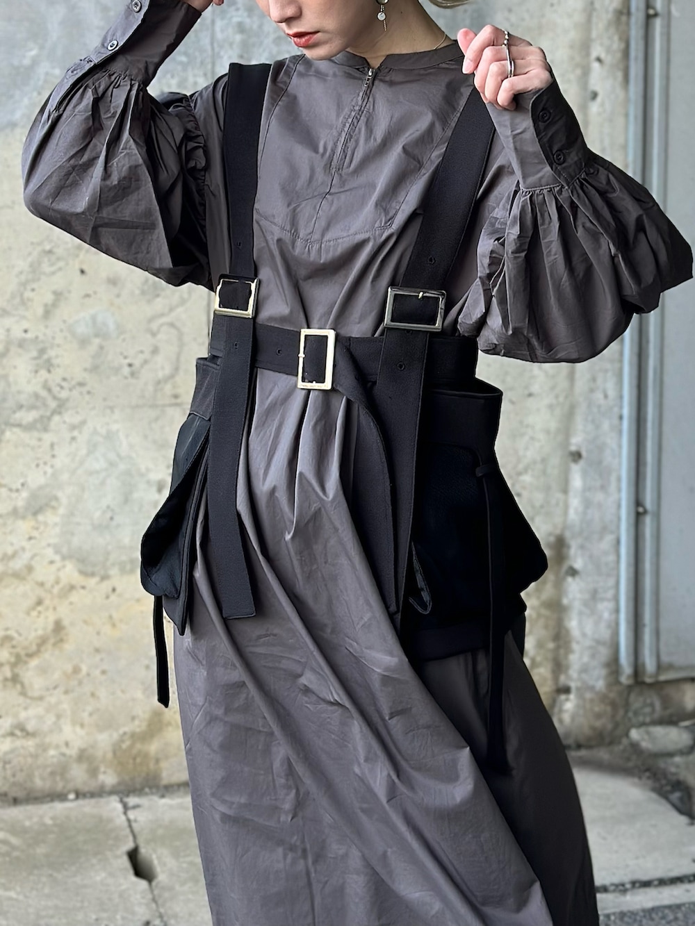 グレー系のワンピース、ホワイト系のその他パンツ、ブラック系のベルトを着用したレディースの冬コーディネートの2枚目の写真