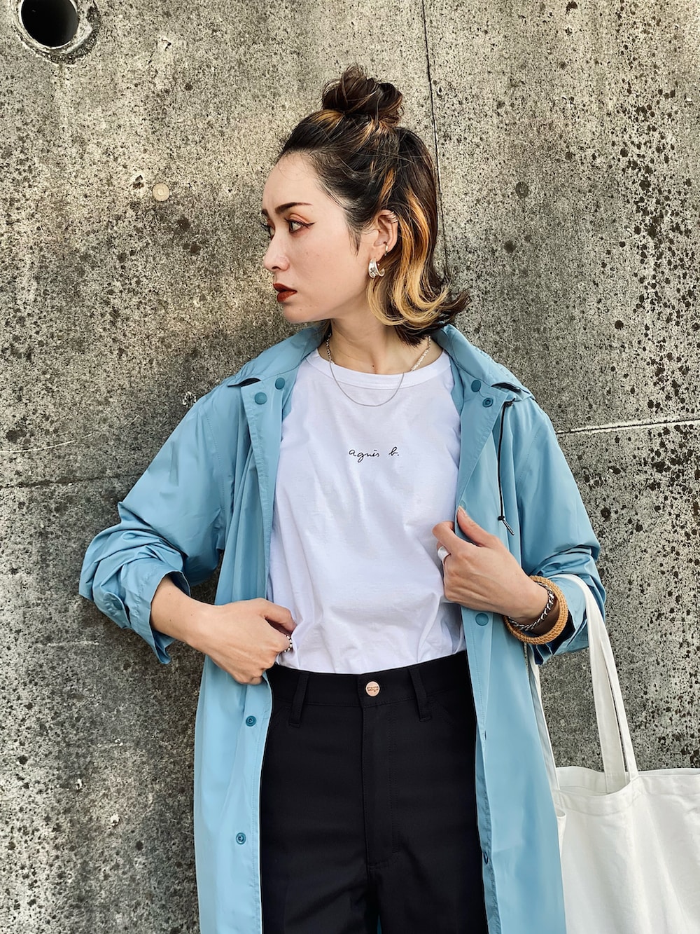 ホワイト系のトートバッグ、ホワイト系のTシャツ/カットソー、ブラック系のスラックスを着用したレディースの春コーディネートの2枚目の写真