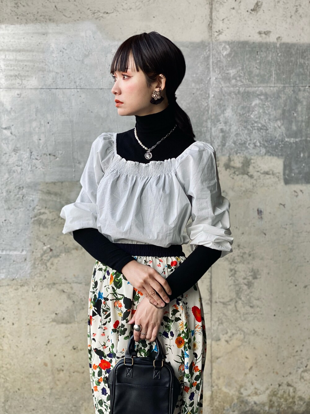 ホワイト系のTシャツ/カットソー、ホワイト系のスカート、ブラック系のショルダーバッグを着用したレディースの春コーディネートの2枚目の写真