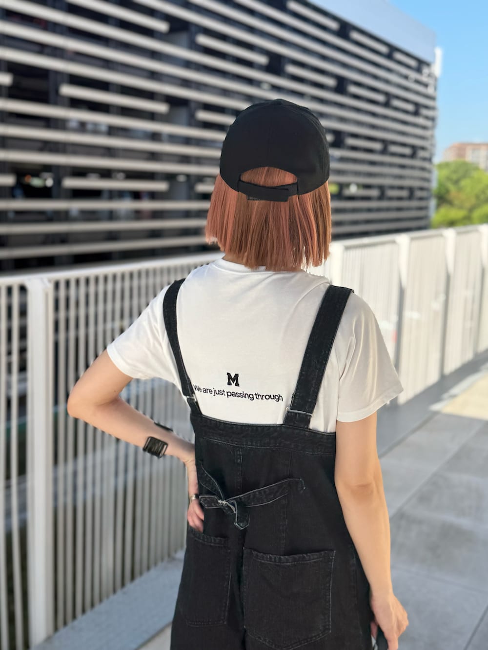 ホワイト系のTシャツ/カットソー、ホワイト系のスニーカー、ブラック系のバッグを着用したレディースの夏コーディネートの3枚目の写真