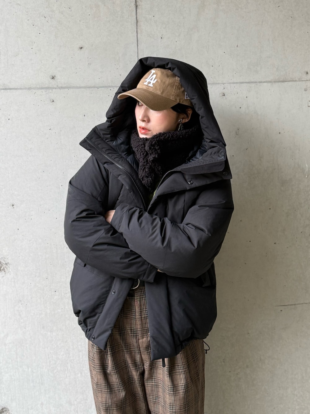 ブラック系のダウンジャケット/コート、ブラウン系のサロペット/オーバーオール、グリーン系のニット/セーターを着用したレディースの冬コーディネートの5枚目の写真