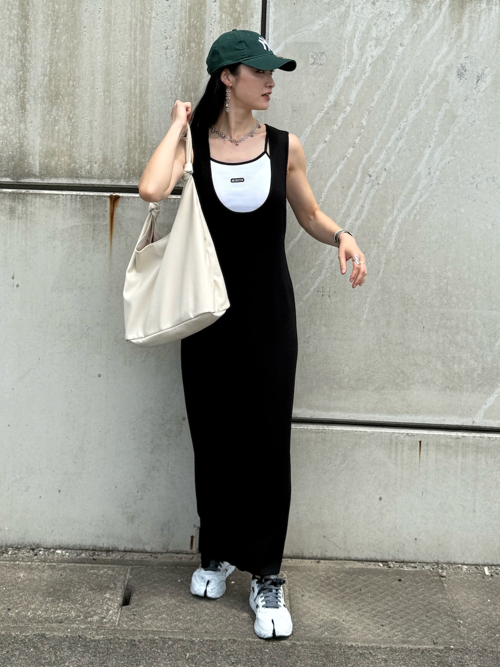 ホワイト系のキャミソール、ホワイト系のトートバッグ、ブラック系のワンピースを着用したレディースの夏コーディネートの4枚目の写真