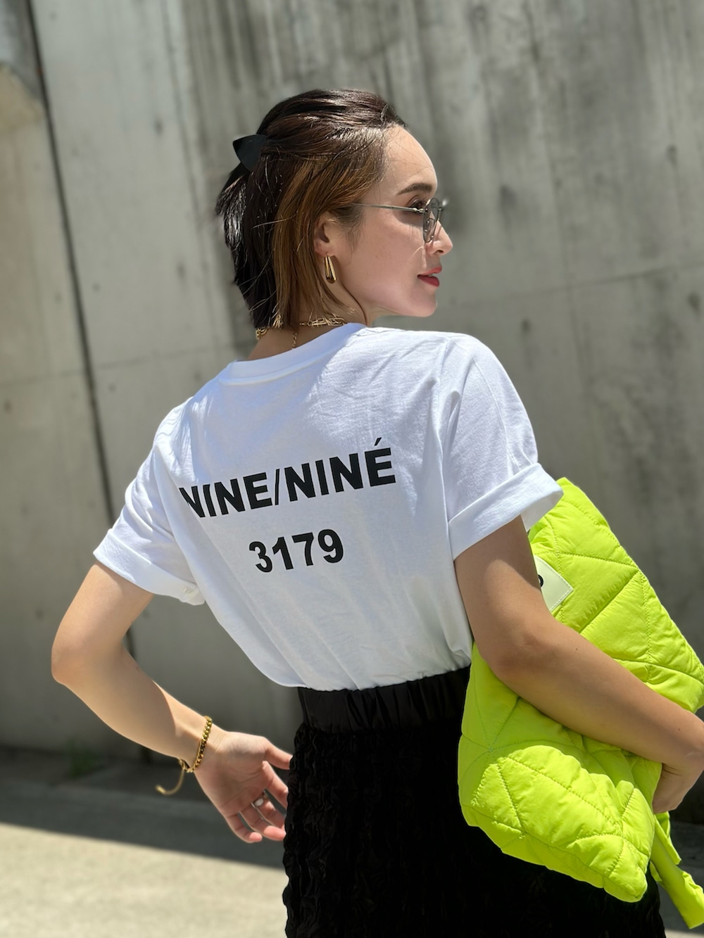 ホワイト系のTシャツ/カットソー、ブラック系のスカート、ブラック系のサンダルを着用したレディースの夏コーディネートの2枚目の写真