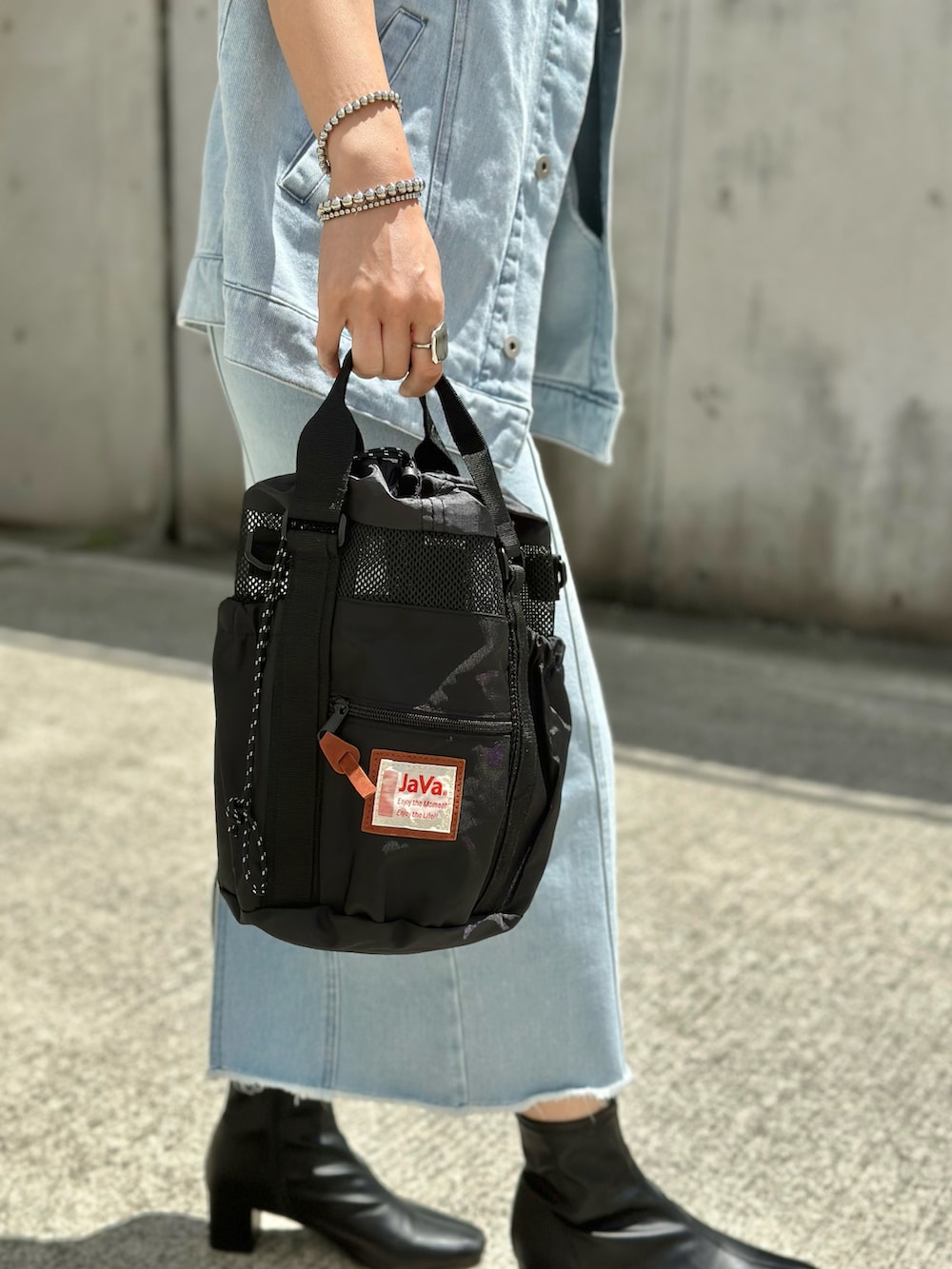 ブルー系のベスト、ブルー系のデニムスカート、ブラック系のTシャツ/カットソーを着用したレディースの春コーディネートの5枚目の写真