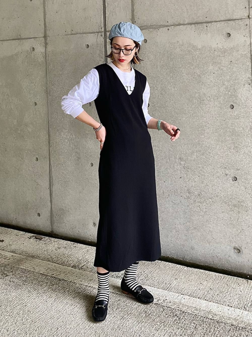 ブラック系のローファー、ブラック系のワンピース、ホワイト系のTシャツ/カットソーを着用したレディースの春コーディネートの2枚目の写真
