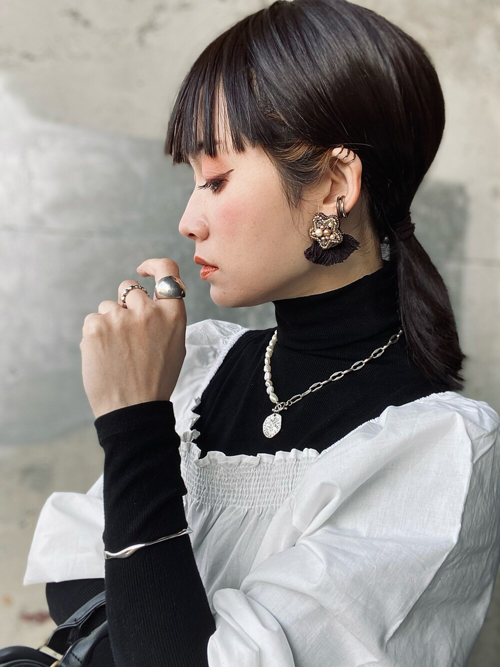 ホワイト系のTシャツ/カットソー、ホワイト系のスカート、ブラック系のショルダーバッグを着用したレディースの春コーディネートの4枚目の写真