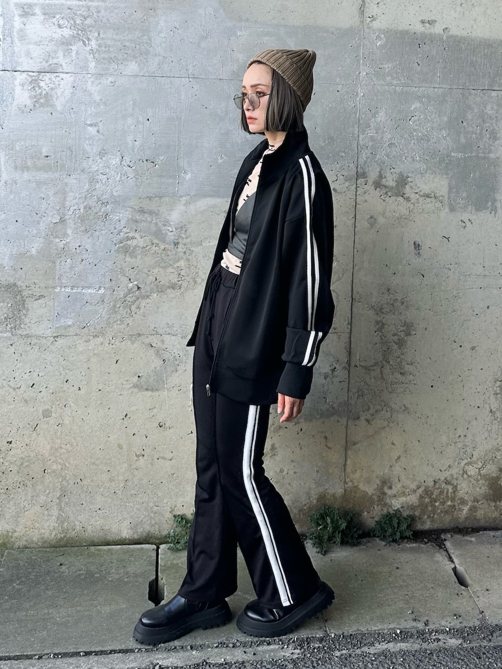 ブラック系のジャージ、ブラック系のスウェットパンツ、ベージュ系のTシャツ/カットソーを着用したレディースの夏コーディネートの4枚目の写真