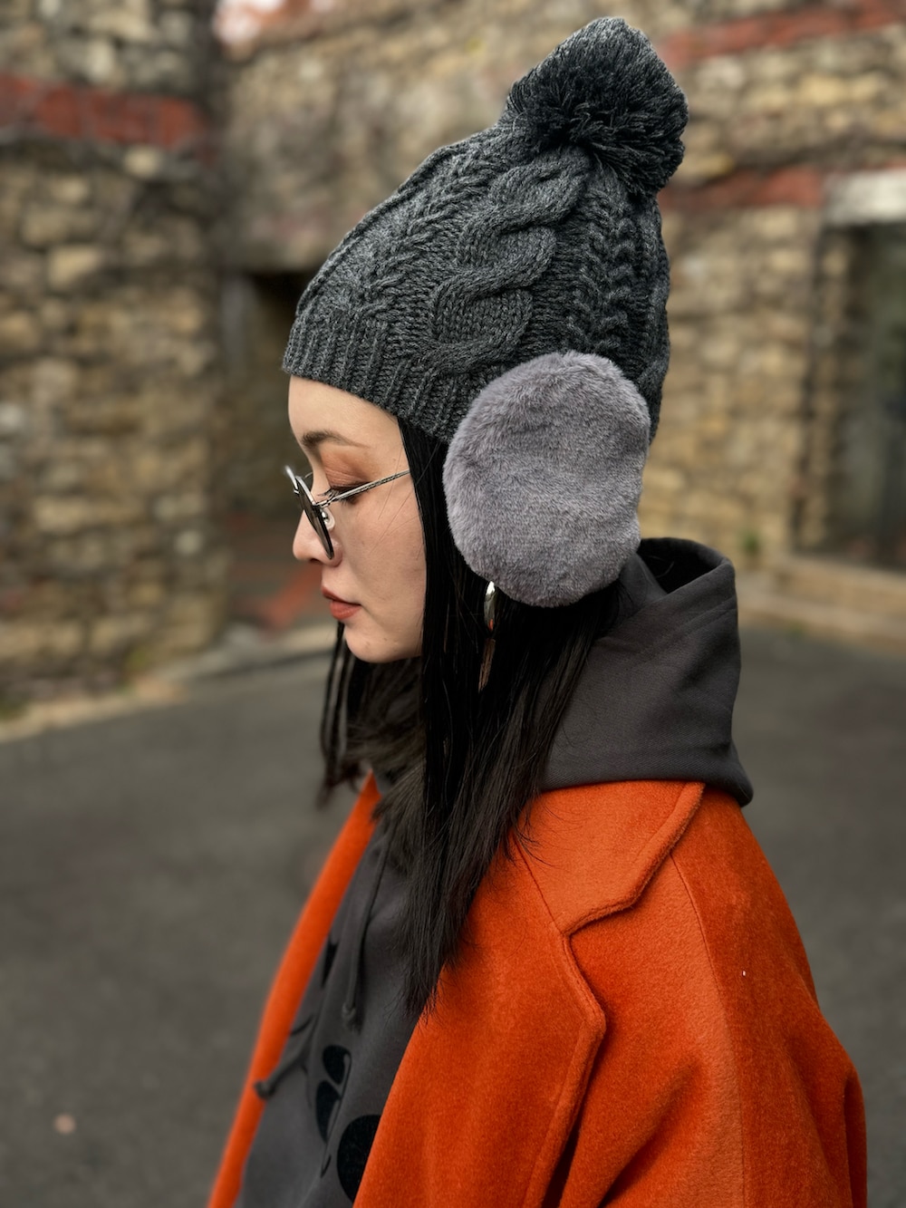 グレー系のパーカー、イエロー系のスリッポン、ブルー系のデニムパンツを着用したレディースの冬コーディネートの2枚目の写真