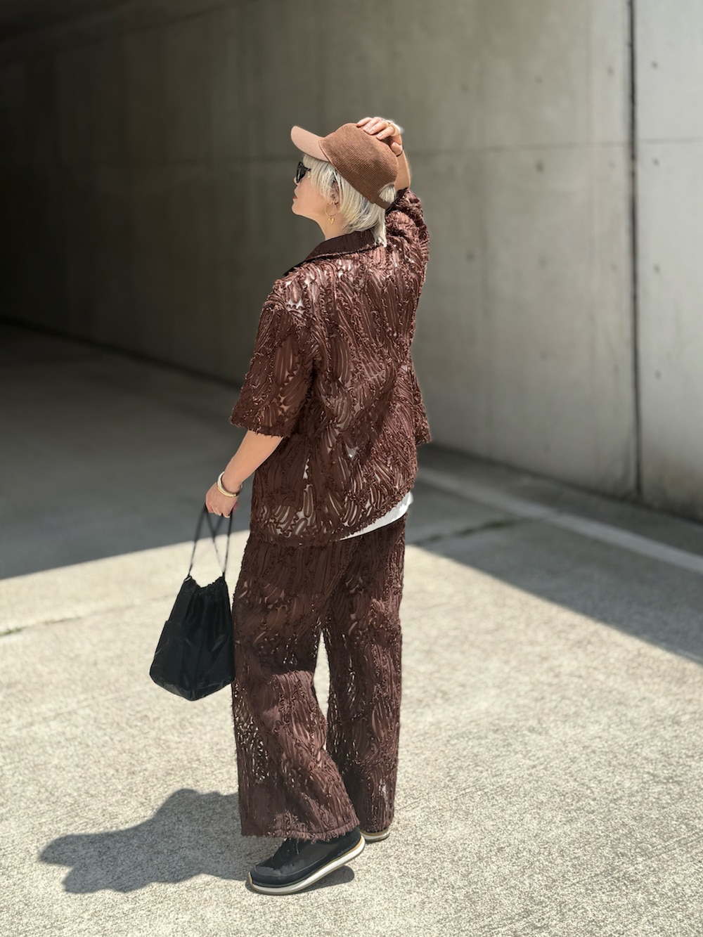 ホワイト系のTシャツ/カットソー、ブラウン系のテーラードジャケット、ブラウン系のスラックスを着用したレディースの春コーディネートの3枚目の写真