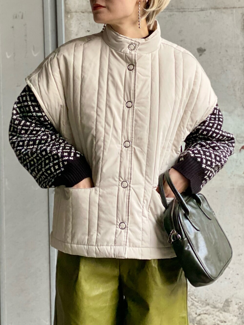 ブラック系のその他トップス、ホワイト系のダウンベスト、グリーン系のその他パンツを着用したレディースの冬コーディネートの4枚目の写真
