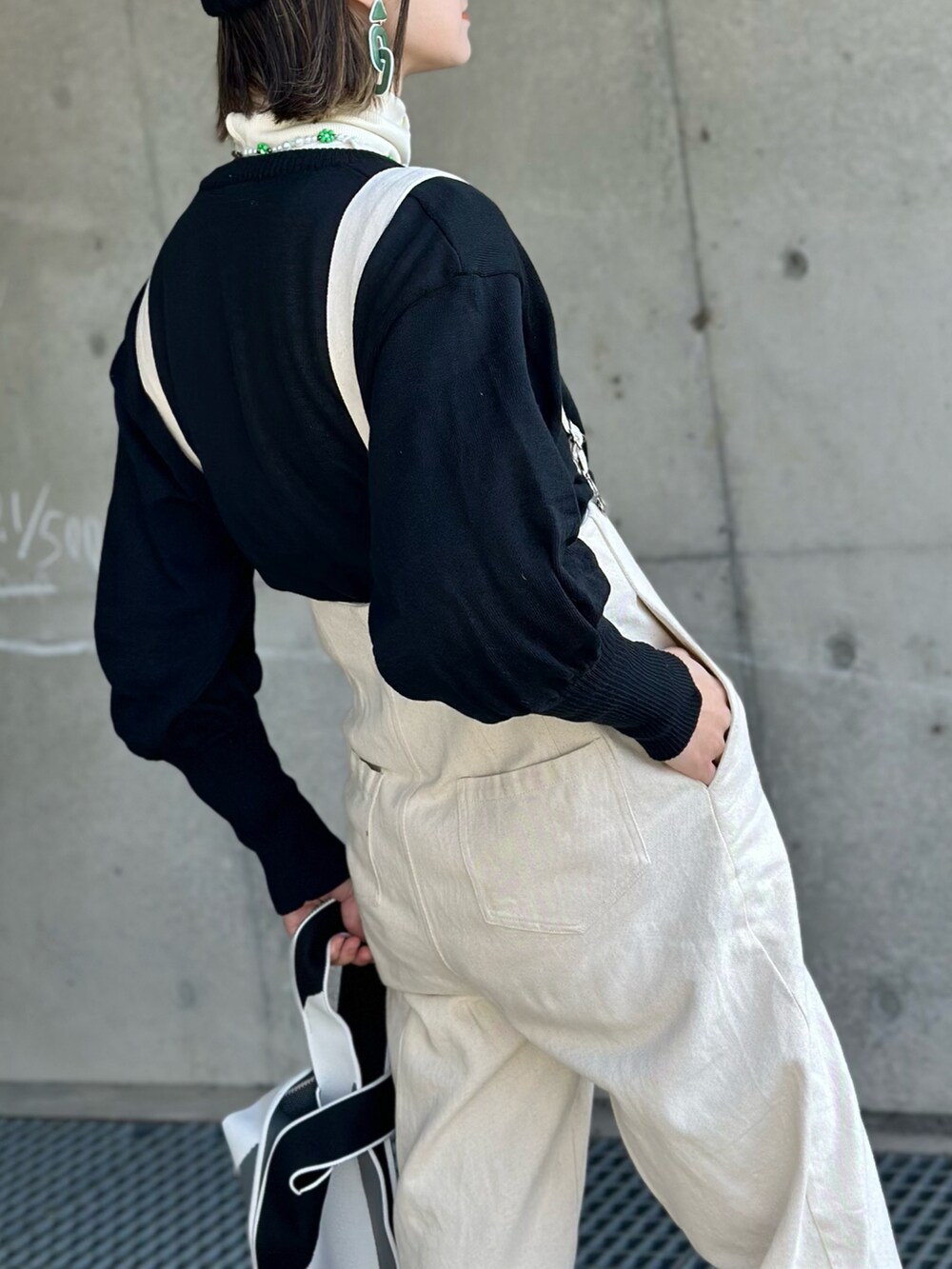 ブラック系のカーディガン/ボレロ、ホワイト系のサロペット/オーバーオール、ブラック系のニットキャップ/ビーニーを着用したレディースの冬コーディネートの4枚目の写真