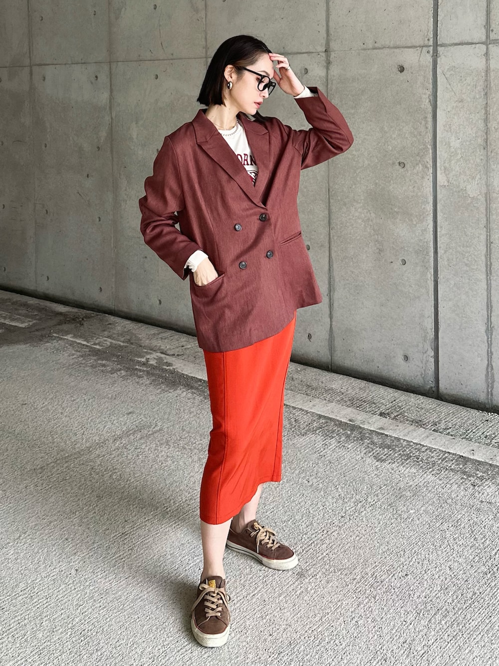 ブラウン系のスーツジャケット、ホワイト系のショルダーバッグ、ホワイト系のブーツを着用したレディースの秋コーディネートの4枚目の写真