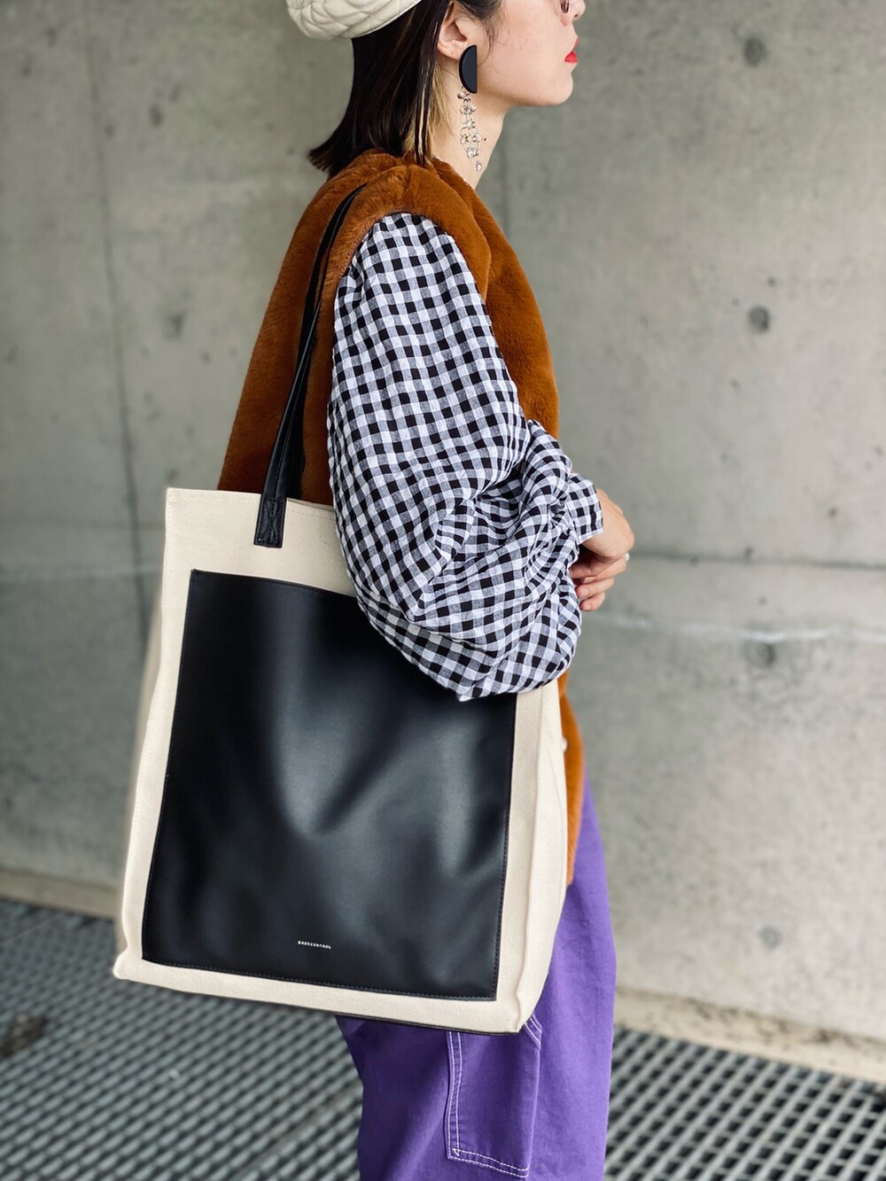 ブラック系のシャツ/ブラウス、イエロー系のベスト、パープル系のデニムパンツを着用したレディースの秋コーディネートの3枚目の写真