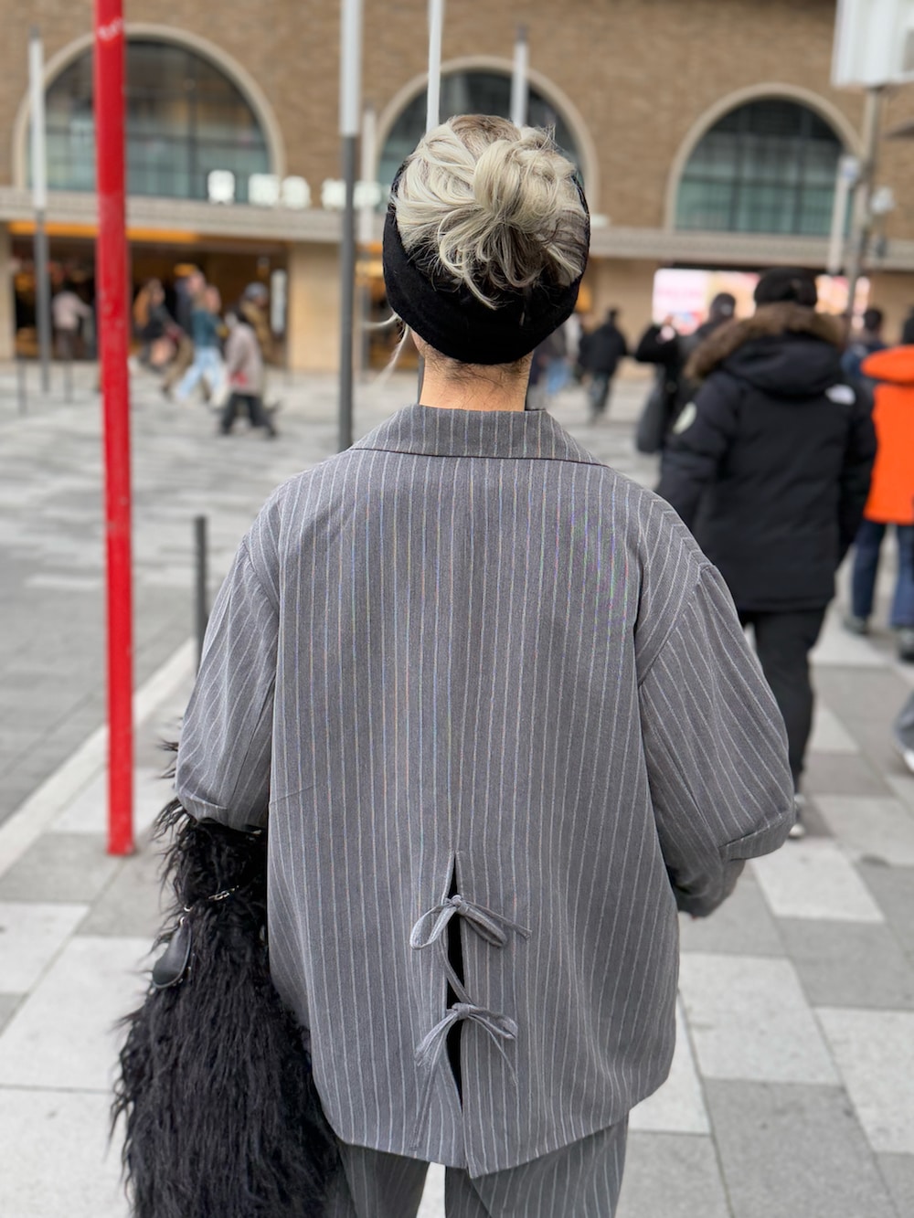 グレー系のセットアップ、ブラック系のニット/セーター、ブラック系のトートバッグを着用したレディースの冬コーディネートの5枚目の写真