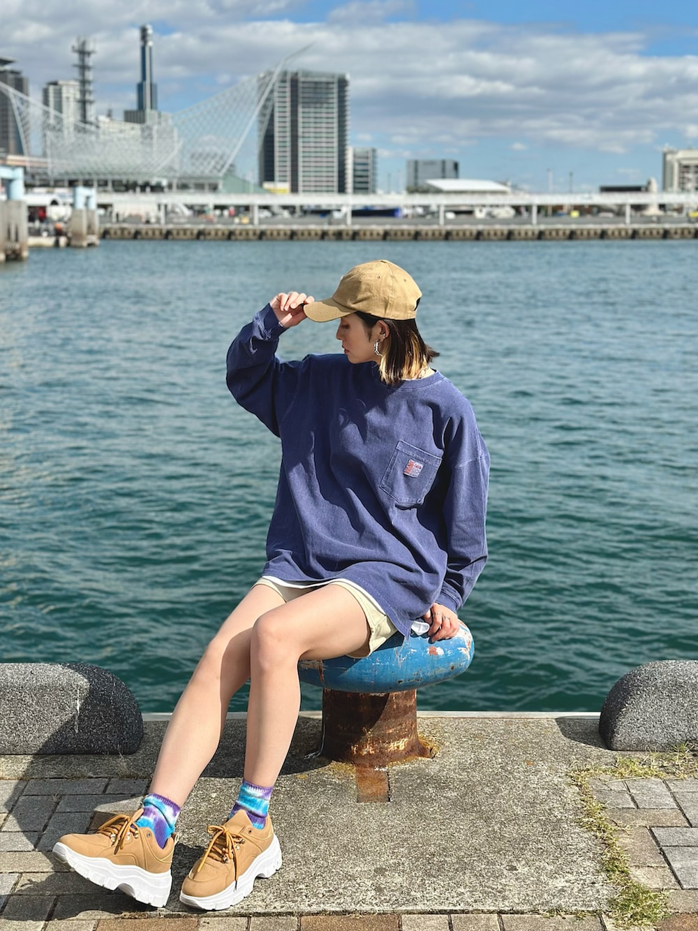 ブルー系のTシャツ/カットソー、イエロー系のベスト、ホワイト系のその他パンツを着用したレディースの冬コーディネートの5枚目の写真