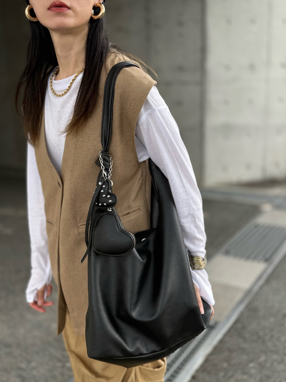 グリーン系のベスト、ホワイト系のTシャツ/カットソー、ベージュ系のスカートを着用したレディースの秋コーディネートの4枚目の写真