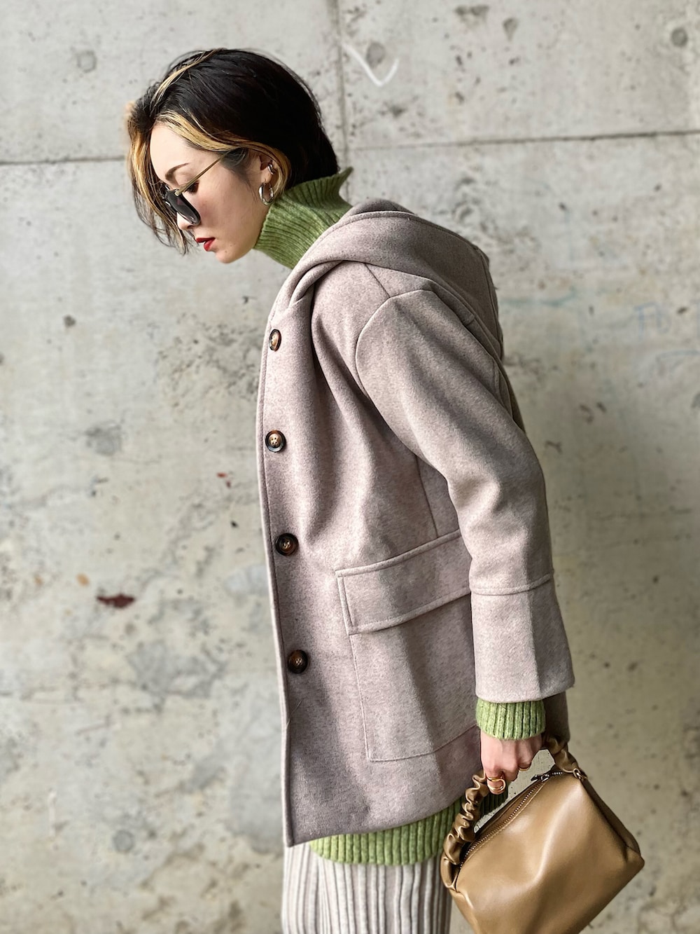 ベージュ系のその他アウター、グリーン系のニット/セーター、ホワイト系のブーツを着用したレディースの冬コーディネートの2枚目の写真