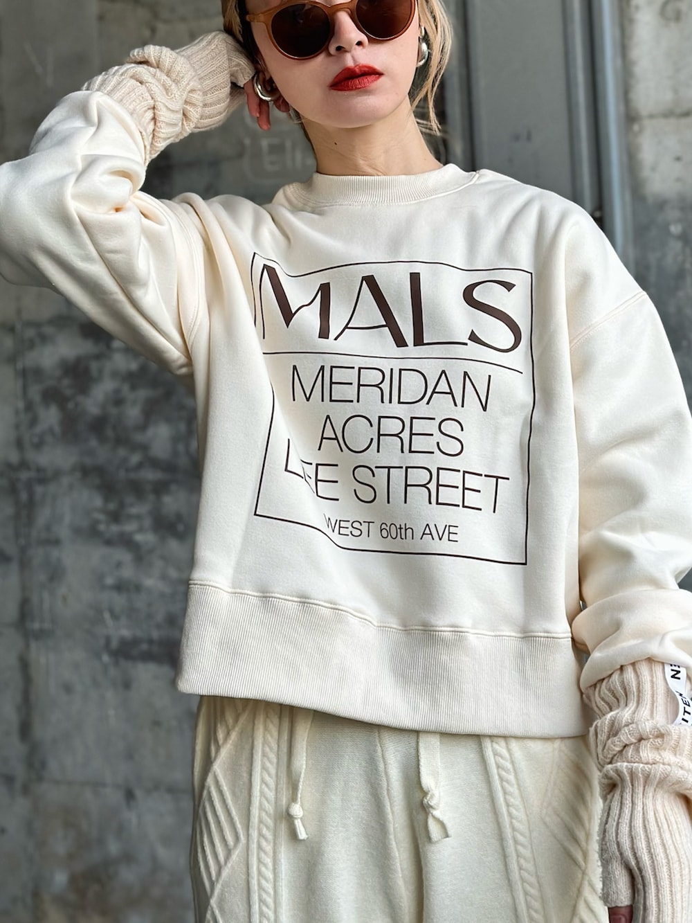 ホワイト系のスウェット、ベージュ系のダウンベスト、ホワイト系のスニーカーを着用したレディースの冬コーディネートの2枚目の写真