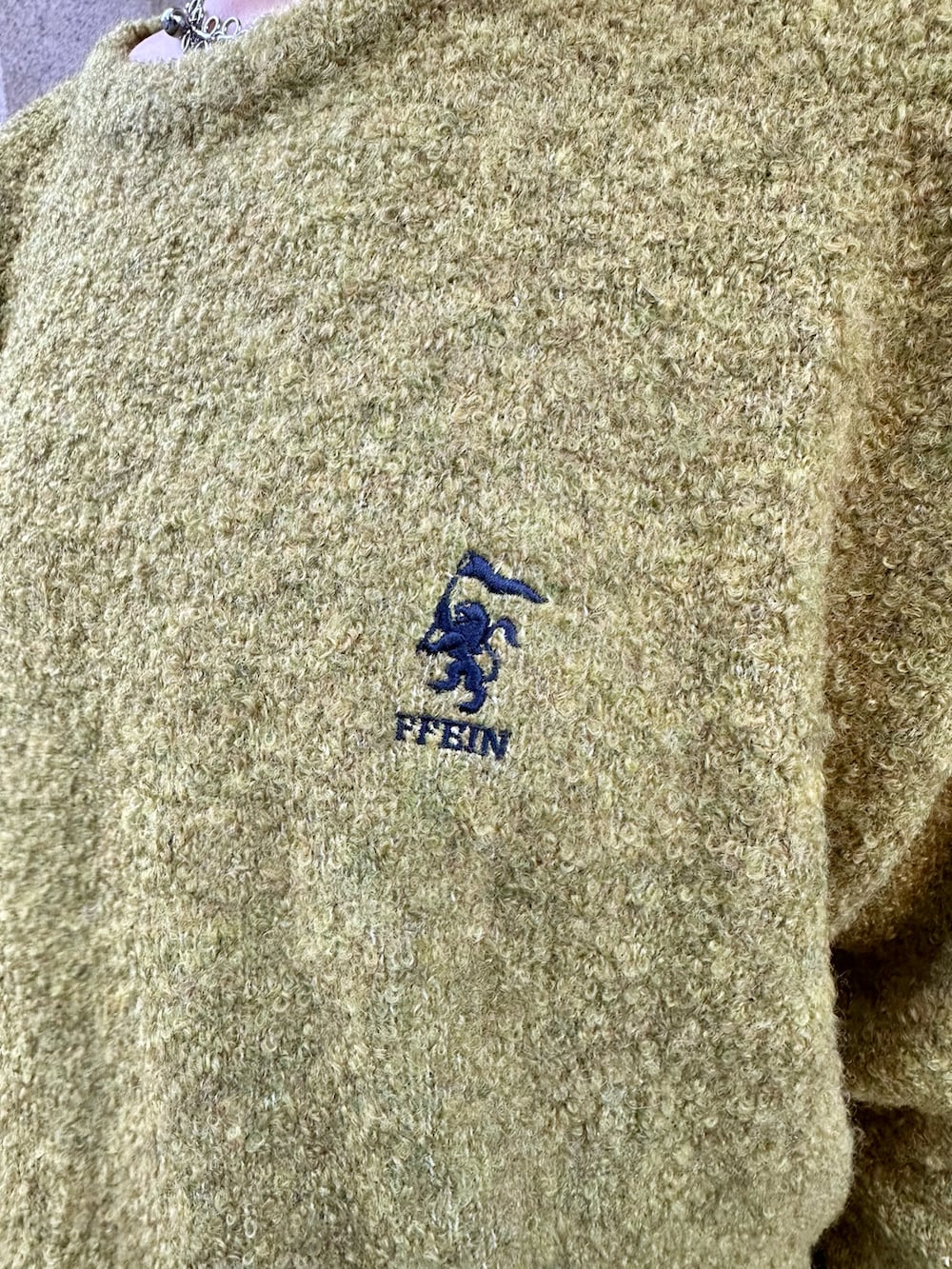 イエロー系のニット/セーター、ブラック系のハンドバッグ、グレー系のスニーカーを着用したレディースの秋コーディネートの5枚目の写真