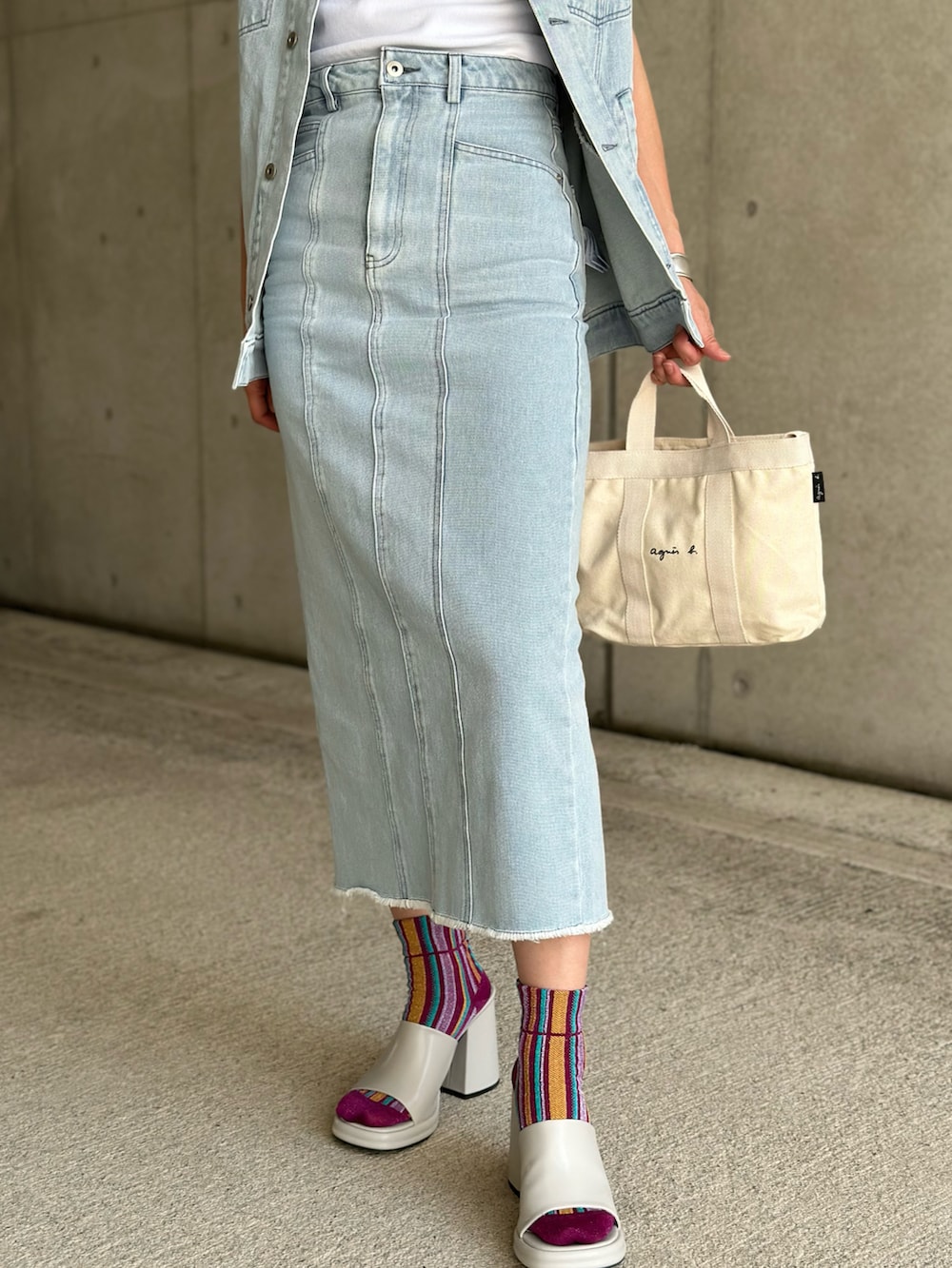 ブルー系のベスト、ブルー系のデニムスカート、ホワイト系のTシャツ/カットソーを着用したレディースの春コーディネートの3枚目の写真