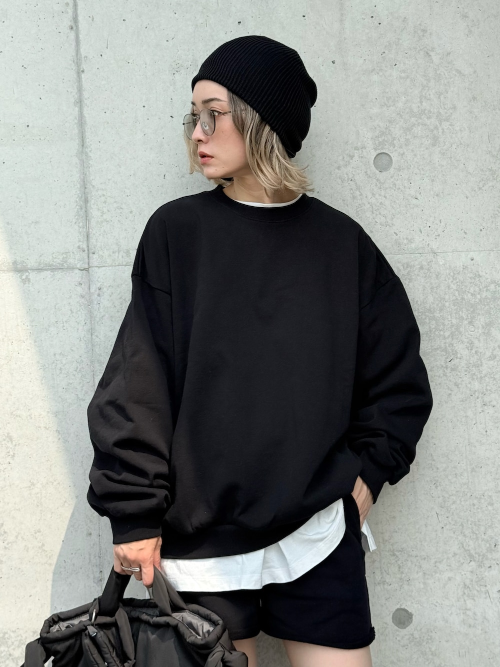 グレー系のスニーカー、グレー系のトートバッグ、ブラック系のセットアップを着用したレディースの秋コーディネートの2枚目の写真