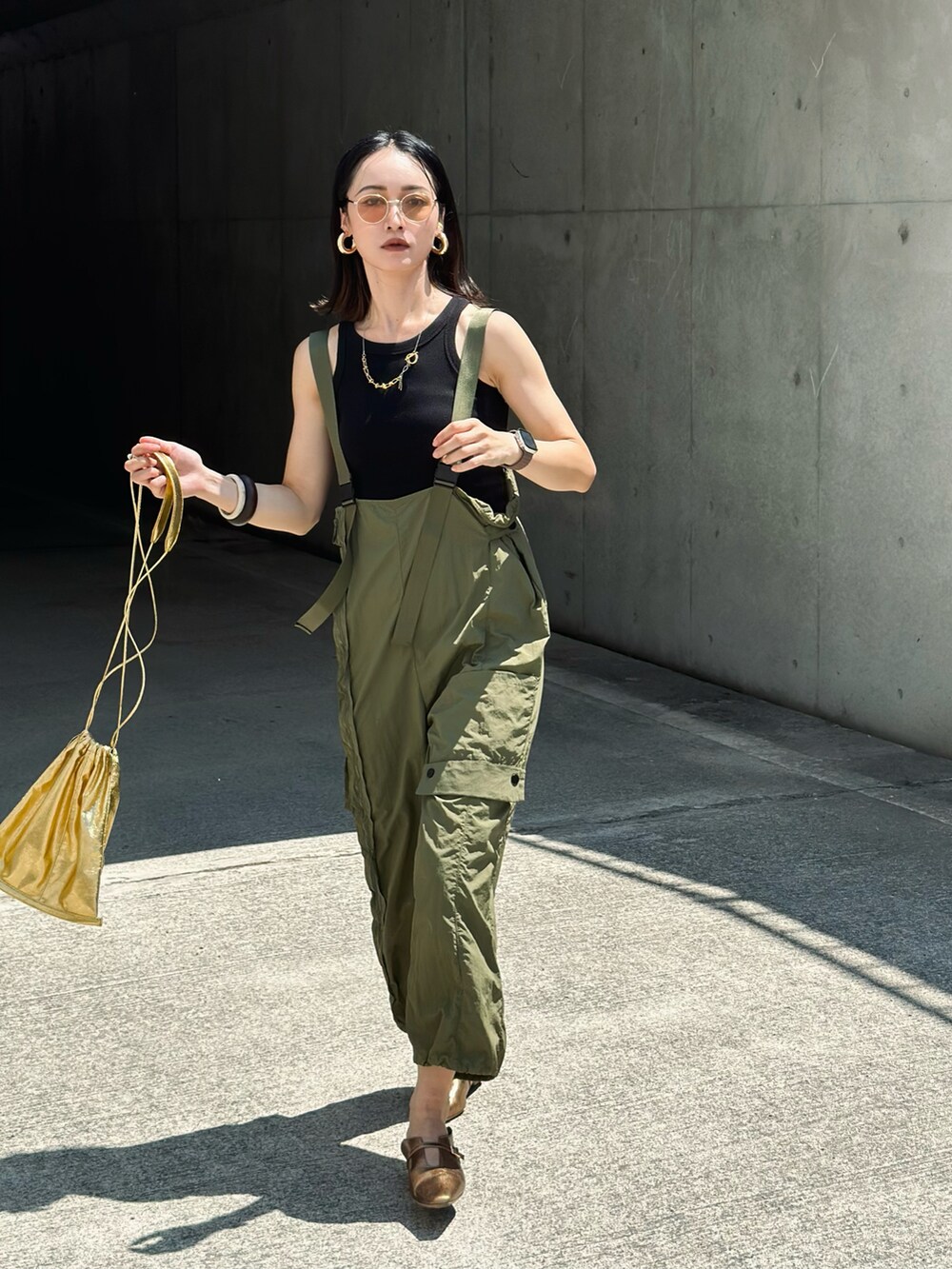 グリーン系のカーゴパンツ、ゴールド系のパンプス、ゴールド系のショルダーバッグを着用したレディースの夏コーディネートの5枚目の写真