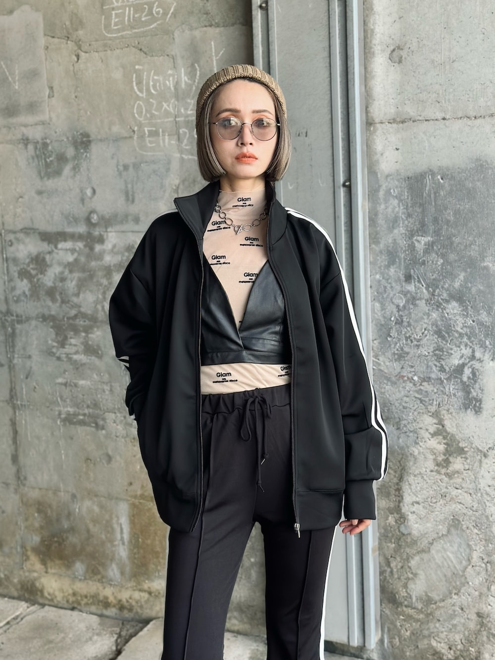 ブラック系のジャージ、ブラック系のスウェットパンツ、ベージュ系のTシャツ/カットソーを着用したレディースの夏コーディネートの2枚目の写真