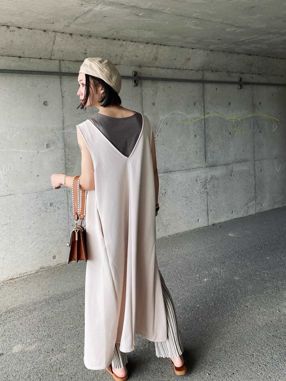 ホワイト系のタンクトップ、ホワイト系のワンピース、ブラウン系のショルダーバッグを着用したレディースの夏コーディネートの3枚目の写真