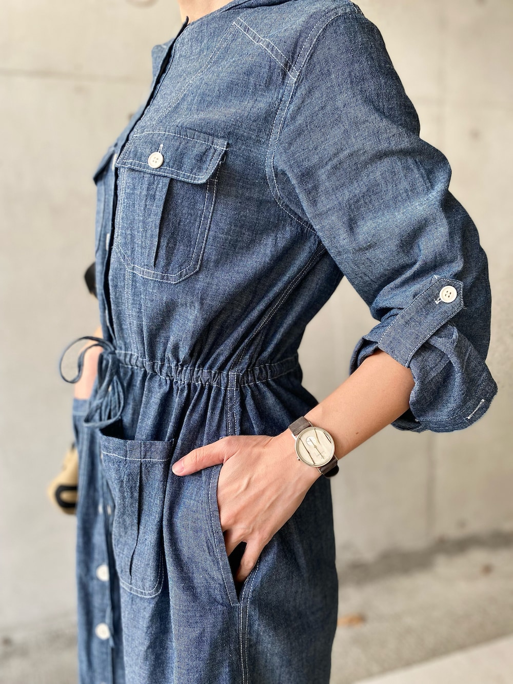 ブルー系のシャツワンピース、ベージュ系のトートバッグ、ブラウン系のサンダルを着用したレディースの春コーディネートの3枚目の写真