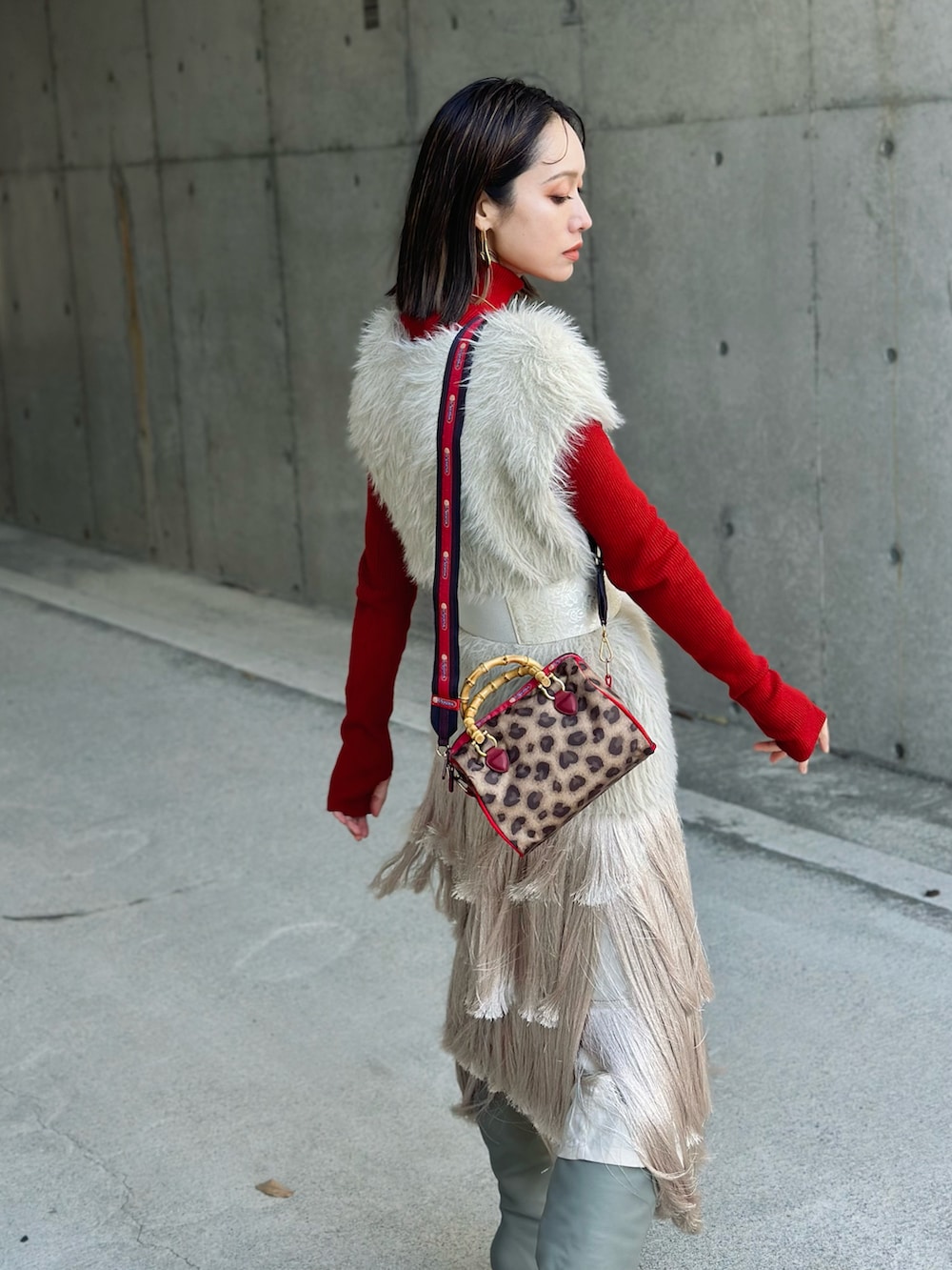 ブラウン系のボストンバッグ、ホワイト系のニット/セーター、ベージュ系のブーツを着用したレディースの秋コーディネートの5枚目の写真