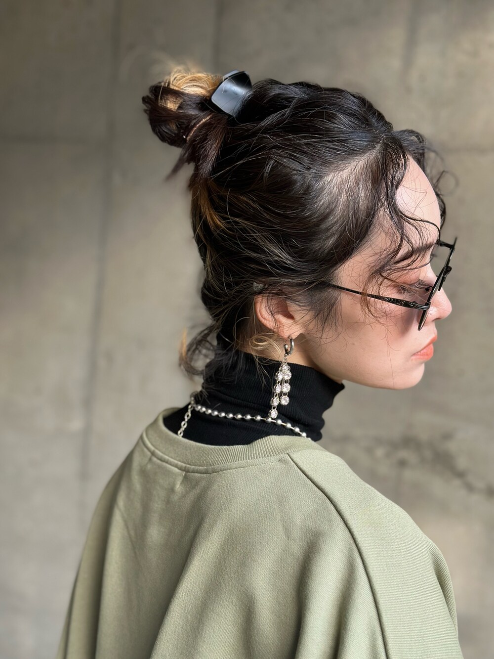 グリーン系のニット/セーター、ブルー系のデニムパンツ、ブラック系のブーツを着用したレディースの冬コーディネートの5枚目の写真