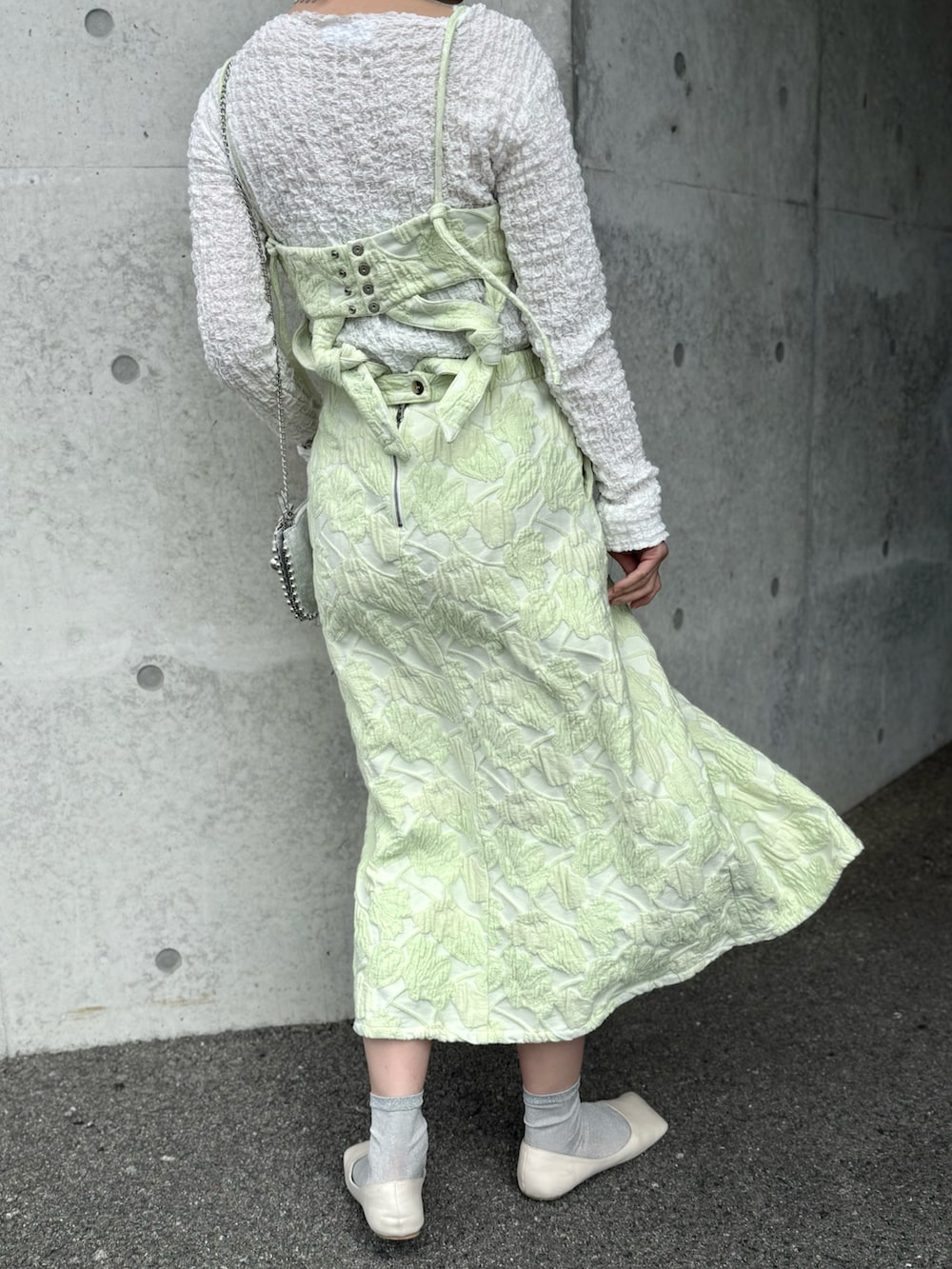 グリーン系のワンピース、ホワイト系のTシャツ/カットソー、シルバー系のピアス(両耳用)を着用したレディースの春コーディネートの4枚目の写真