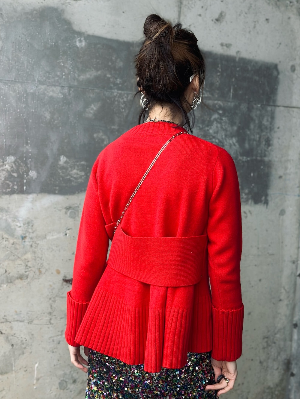 レッド系のニット/セーター、レッド系のブーツ、その他のスカートを着用したレディースの冬コーディネートの3枚目の写真