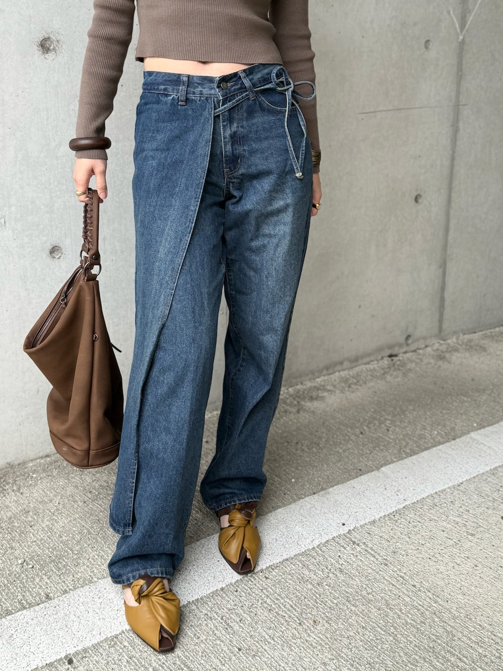 ブラウン系のショルダーバッグ、イエロー系のサンダル、グリーン系のニット/セーターを着用したレディースの春コーディネートの3枚目の写真