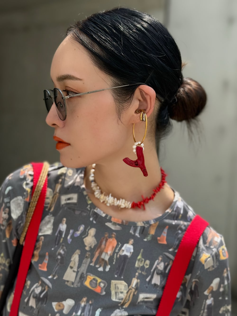 レッド系のニット/セーター、グレー系のショルダーバッグ、グレー系のTシャツ/カットソーを着用したレディースの夏コーディネートの3枚目の写真