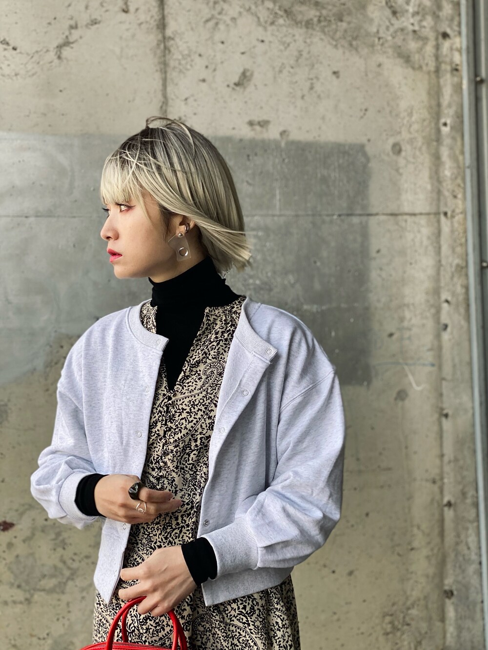 ブラック系のワンピース、グレー系のスウェット、ブラック系のパンプスを着用したレディースの春コーディネートの3枚目の写真