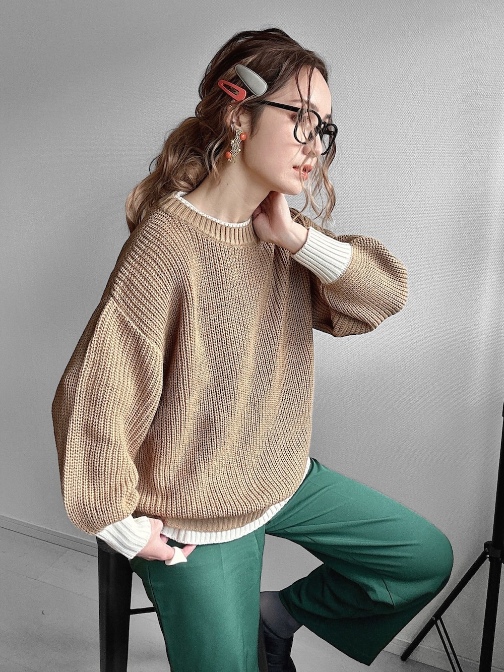 ブラック系のダウンベスト、グリーン系のスラックス、イエロー系のニット/セーターを着用したレディースの冬コーディネートの2枚目の写真