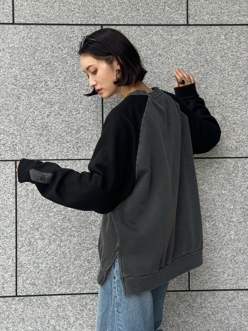 ブルー系のデニムパンツ、グレー系のスウェットを着用したレディースの秋コーディネートの5枚目の写真