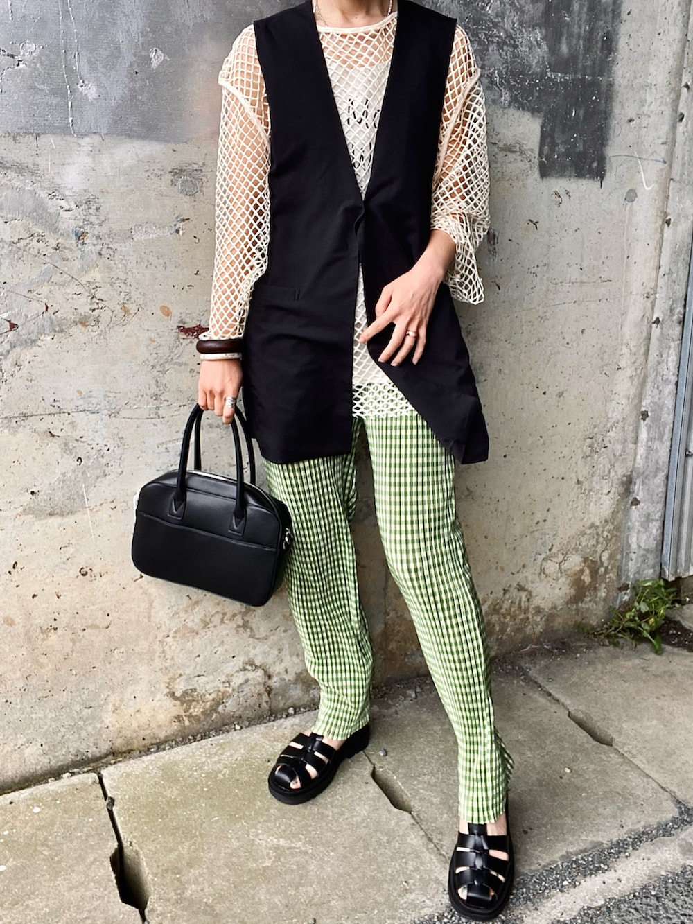 ブラック系のベスト、グリーン系のその他パンツ、ブラック系のサンダルを着用したレディースの春コーディネートの3枚目の写真