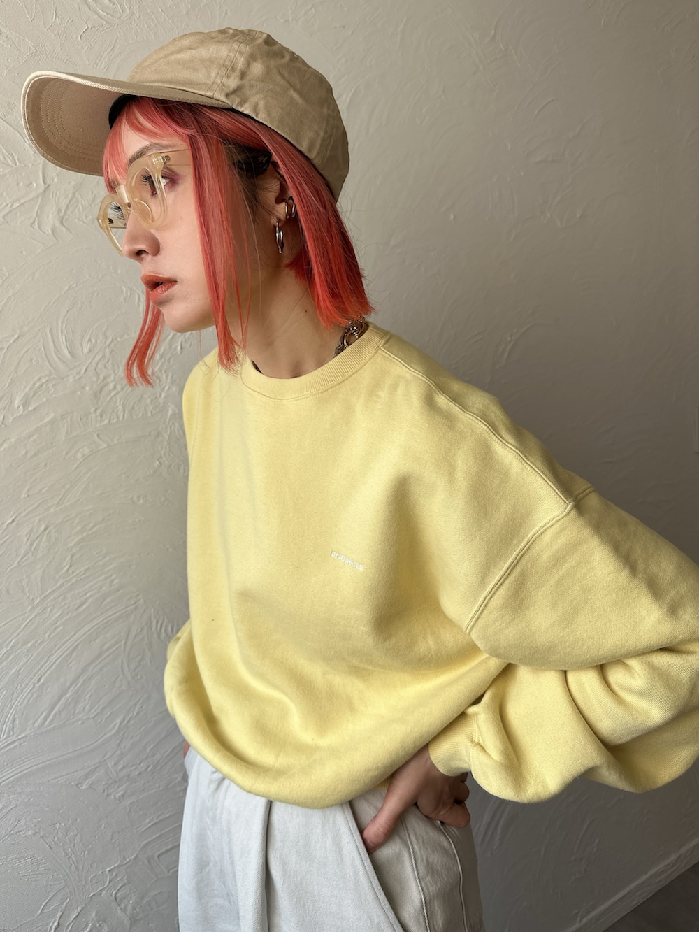 イエロー系のスウェット、ブルー系のデニムパンツ、ベージュ系のスニーカーを着用したレディースの春コーディネートの4枚目の写真