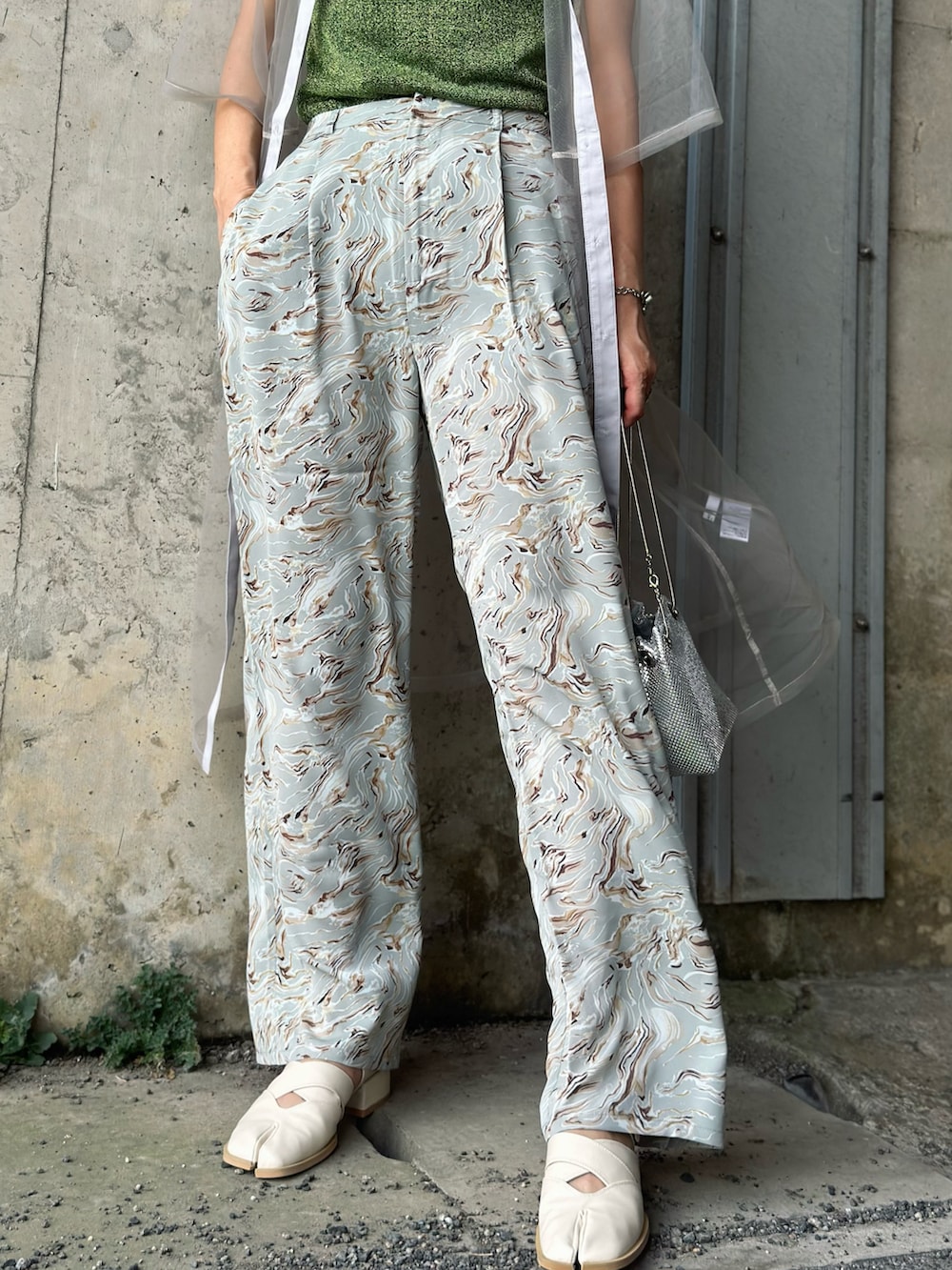 グレー系のワンピース、グリーン系のTシャツ/カットソー、グレー系のスラックスを着用したレディースの夏コーディネートの3枚目の写真