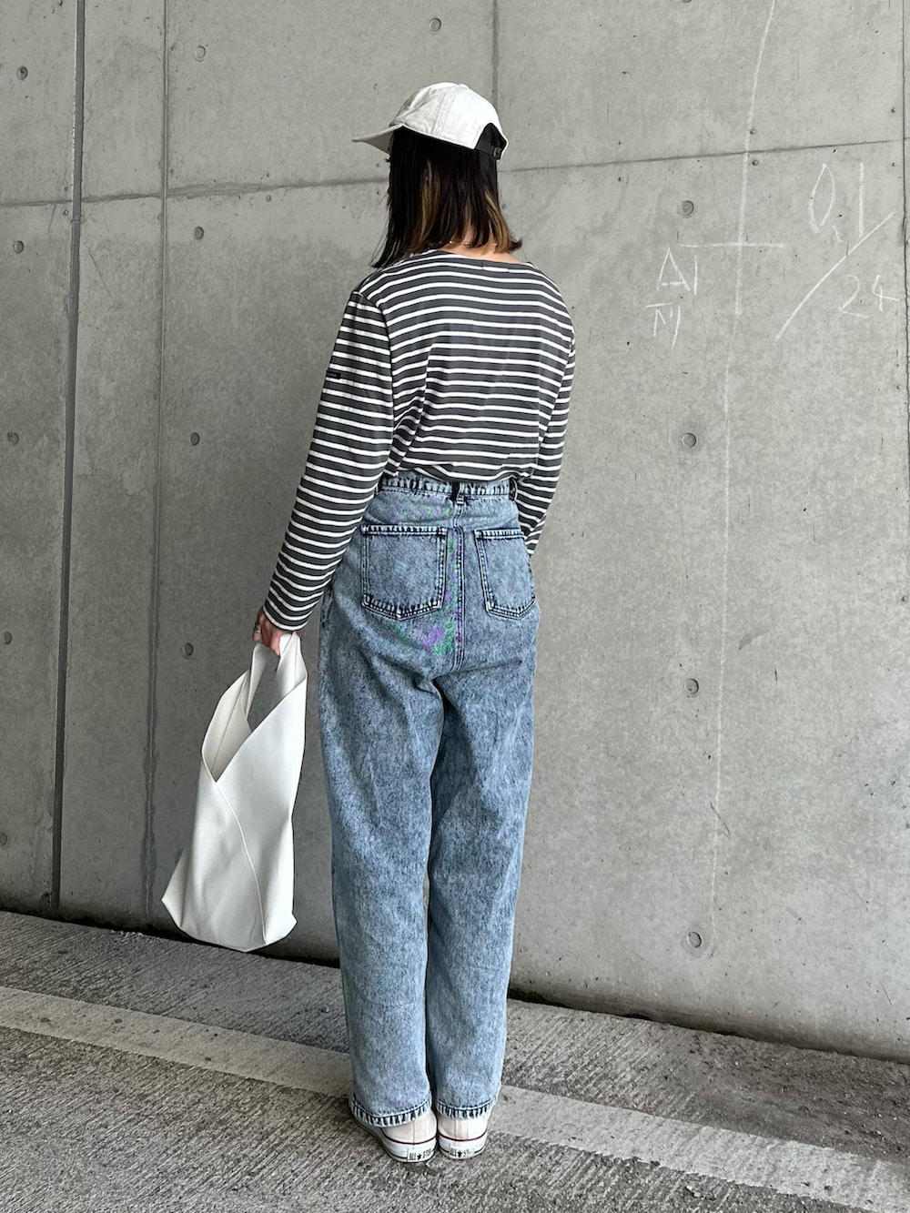 ホワイト系のトートバッグ、ブルー系のデニムパンツを着用したレディースの冬コーディネートの3枚目の写真