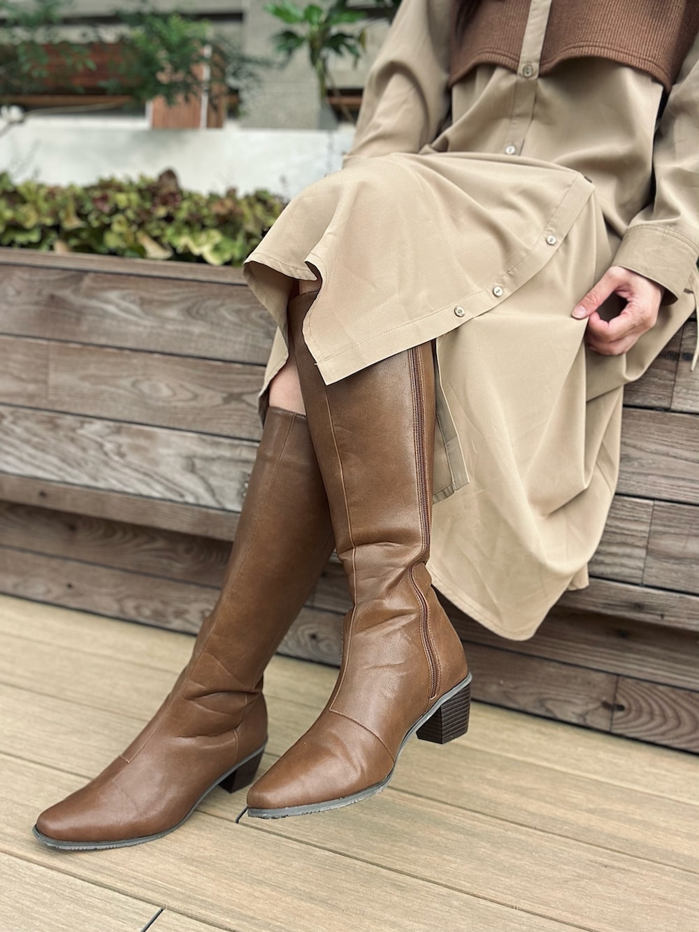 ブラウン系のブーツ、ベージュ系のワンピース、イエロー系のハンドバッグを着用したレディースの秋コーディネートの2枚目の写真