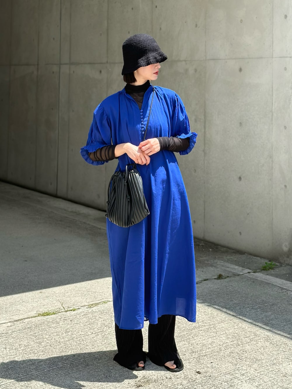 ブルー系のワンピース、ブラック系のトートバッグ、ブラック系のサンダルを着用したレディースの春コーディネートの2枚目の写真