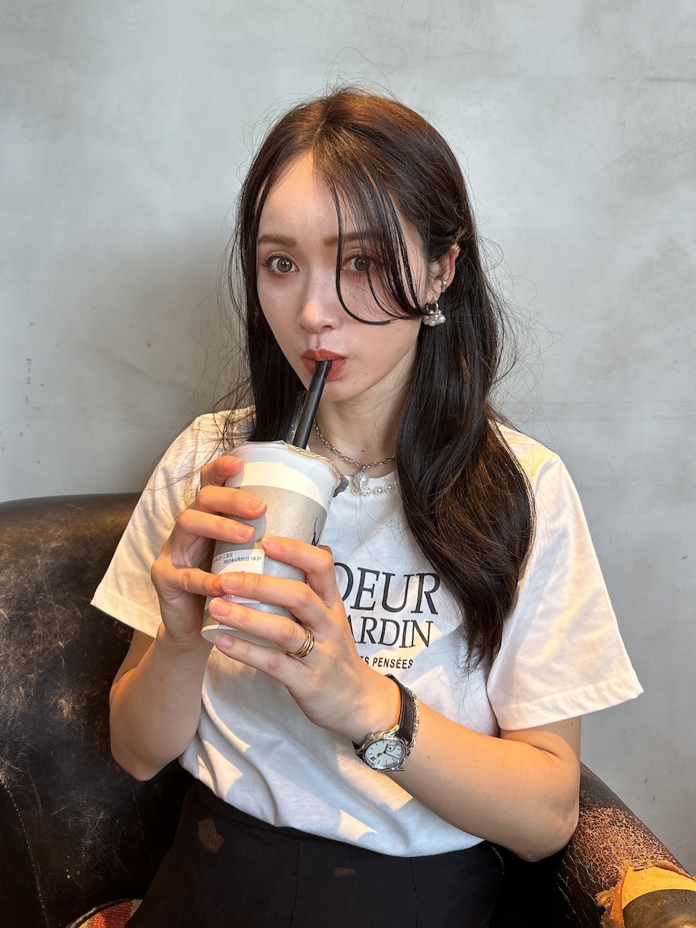 ホワイト系のTシャツ/カットソー、シルバー系のサンダル、ブラック系のスカートを着用したレディースの春コーディネートの2枚目の写真