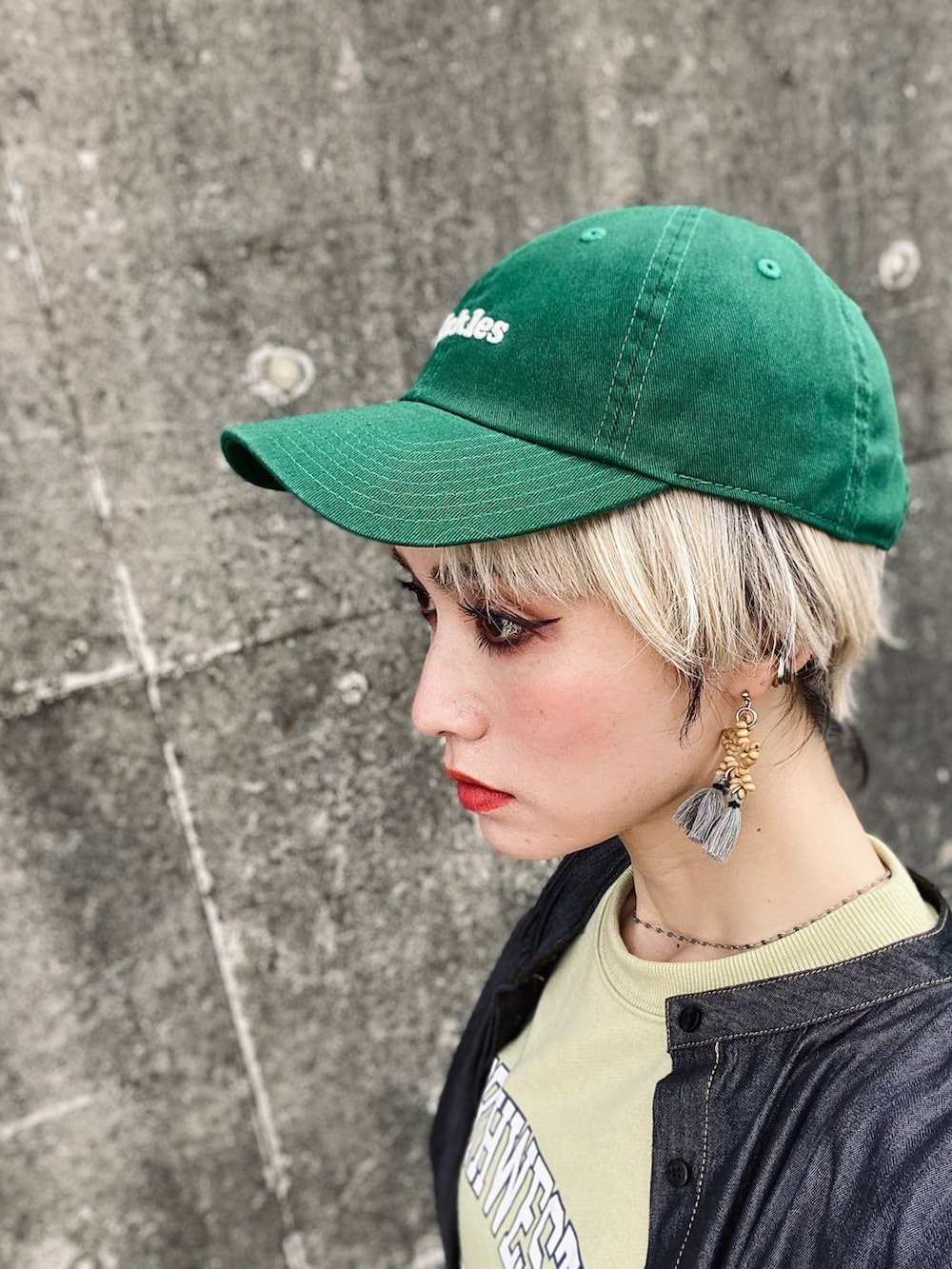 グリーン系のスウェット、ホワイト系のデニムパンツ、ブラック系のサンダルを着用したレディースの春コーディネートの2枚目の写真