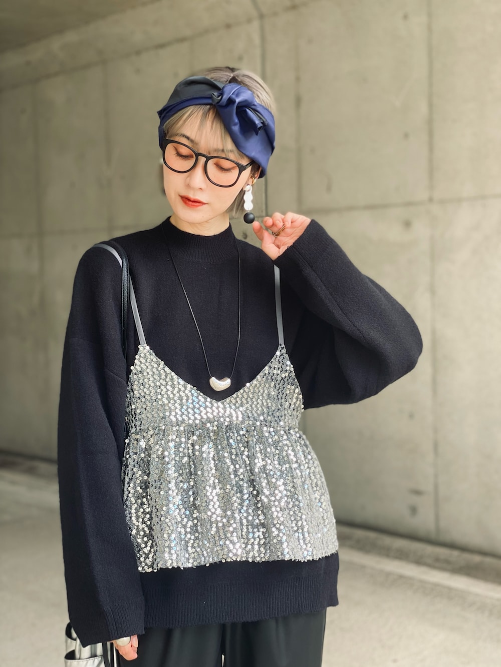 ブラック系のニット/セーター、ブラック系のその他パンツ、シルバー系のキャミソールを着用したレディースの秋コーディネートの2枚目の写真