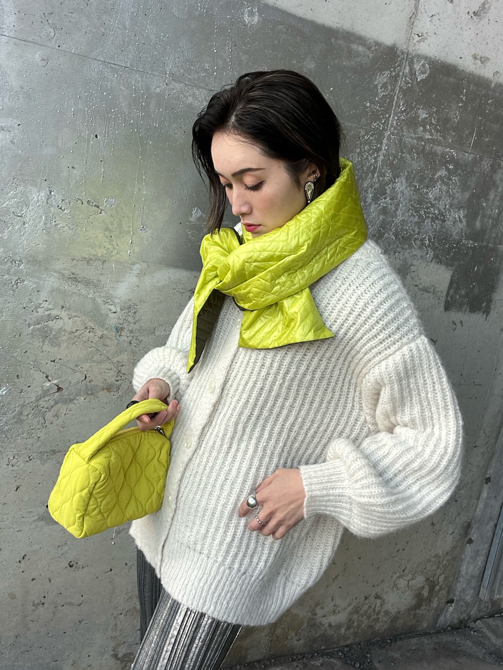 ホワイト系のカーディガン/ボレロ、イエロー系のショルダーバッグ、ホワイト系のパンプスを着用したレディースの冬コーディネートの2枚目の写真