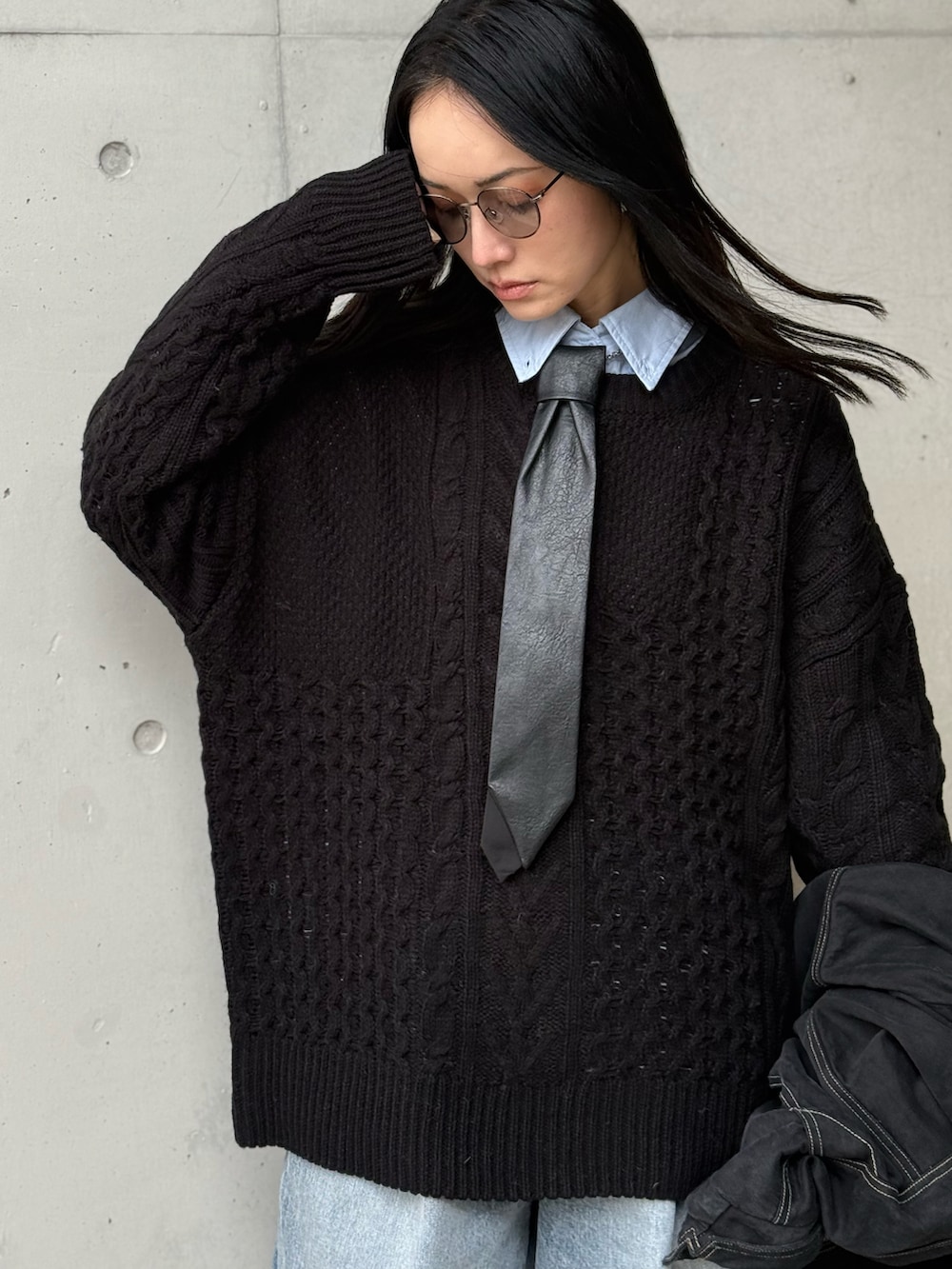 ブラック系のニット/セーター、ブルー系のデニムパンツ、その他のネクタイを着用したレディースの冬コーディネートの2枚目の写真